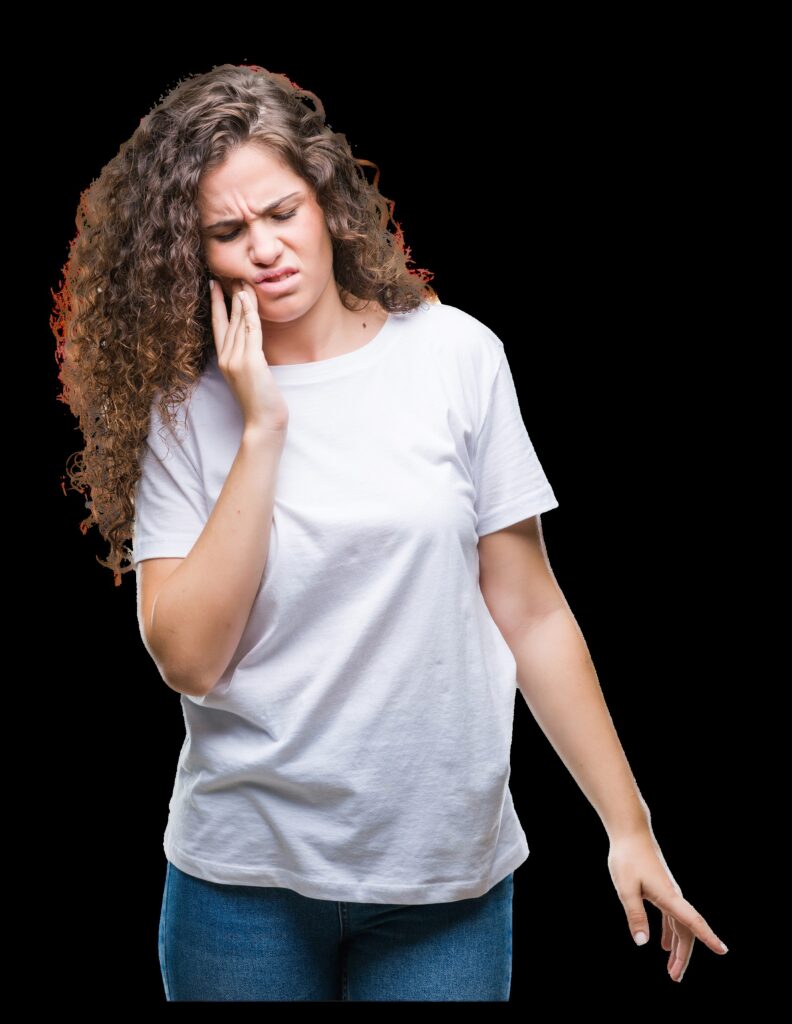A woman winces while touching her cheek as though she is experiencing a toothache and may need an emergency dentist visit.