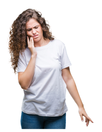 A woman winces while touching her cheek as though she is experiencing a toothache and may need an emergency dentist visit.