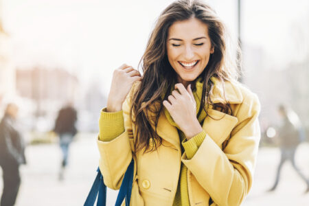 A woman smiles a beautiful smile. Metal-free dentistry restores smiles seamlessly and beautifully.