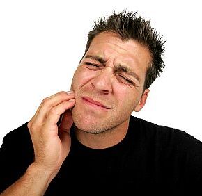 A man holds his face as though he is experiencing pain from a toothache and may need an emergency dentist visit. Angels Smile is open 6 days a week, including Saturdays.