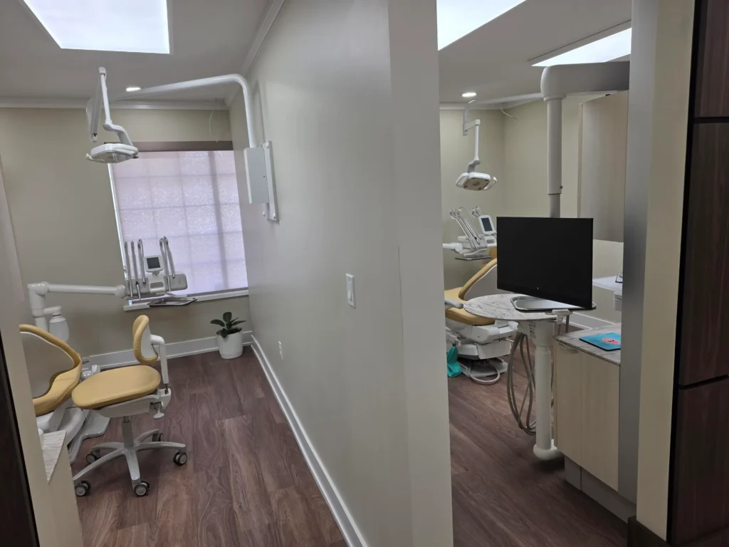 Two treatment rooms with dental chairs and computer monitors