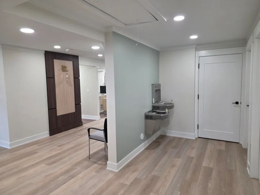 Hallway with a drinking fountain and a chair near the treatment rooms