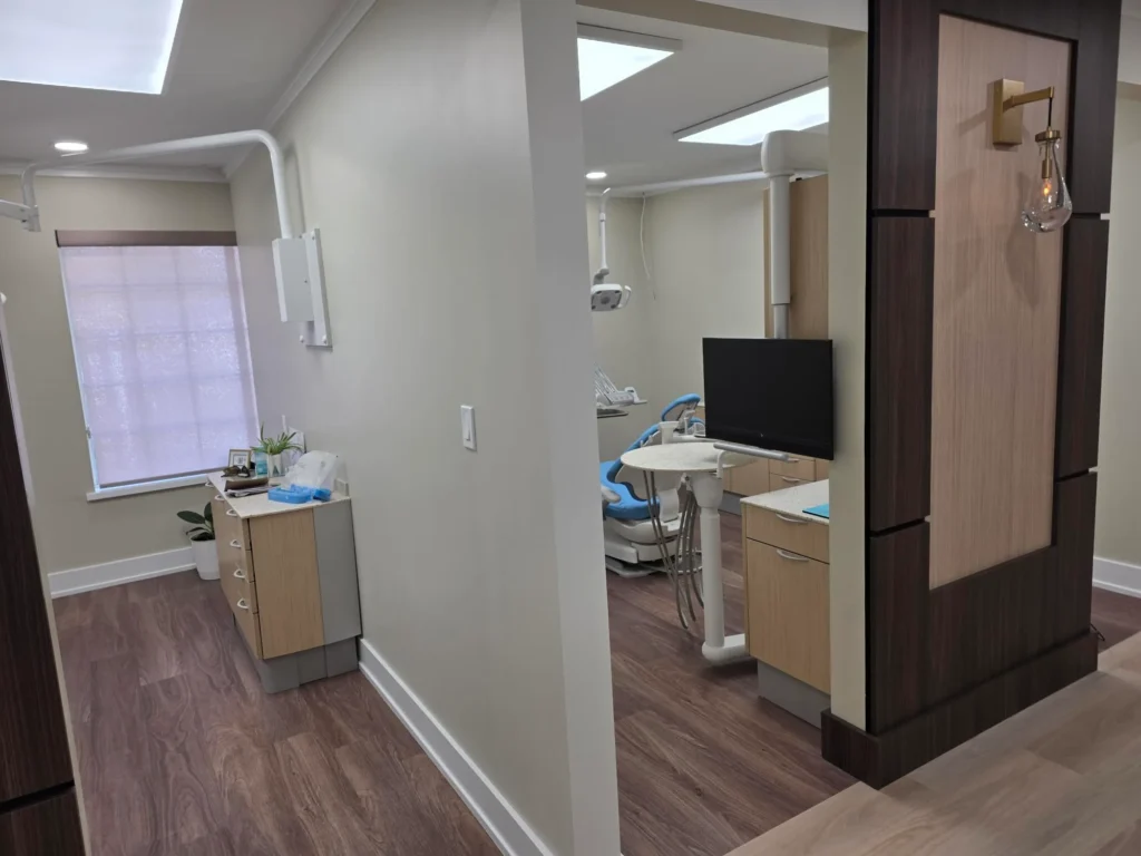 Treatment room with a dental chair, overhead light and monitor