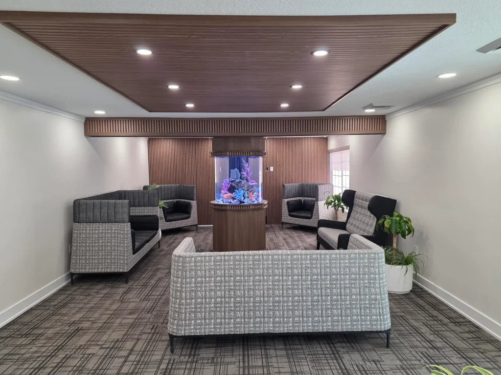 Waiting room with lounge seating arranged around a central aquarium